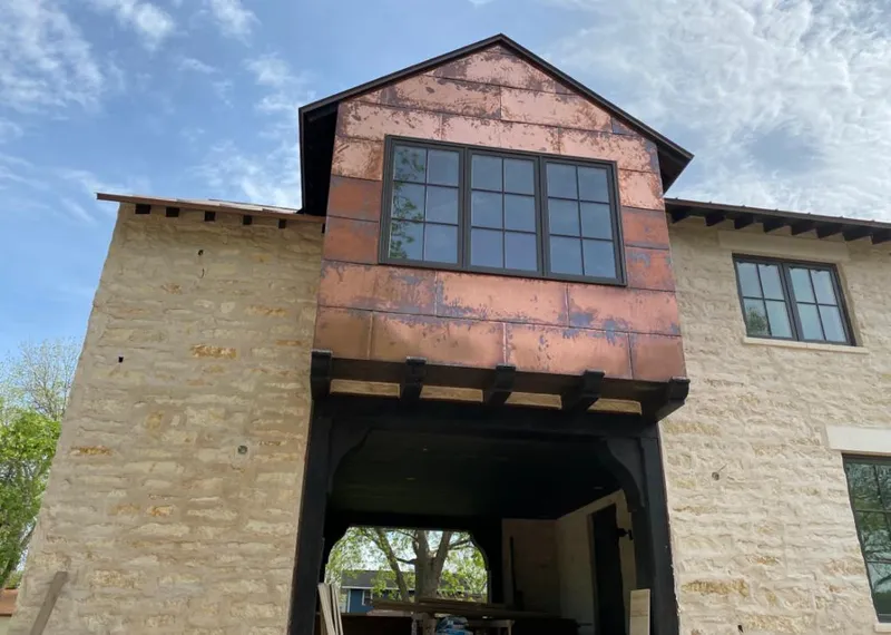 Copper metal panel facade on a stone building for Metal Roof Coating in Bright