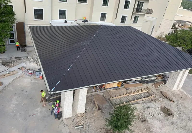 Metal roofing installation team working on a commercial building in Bright