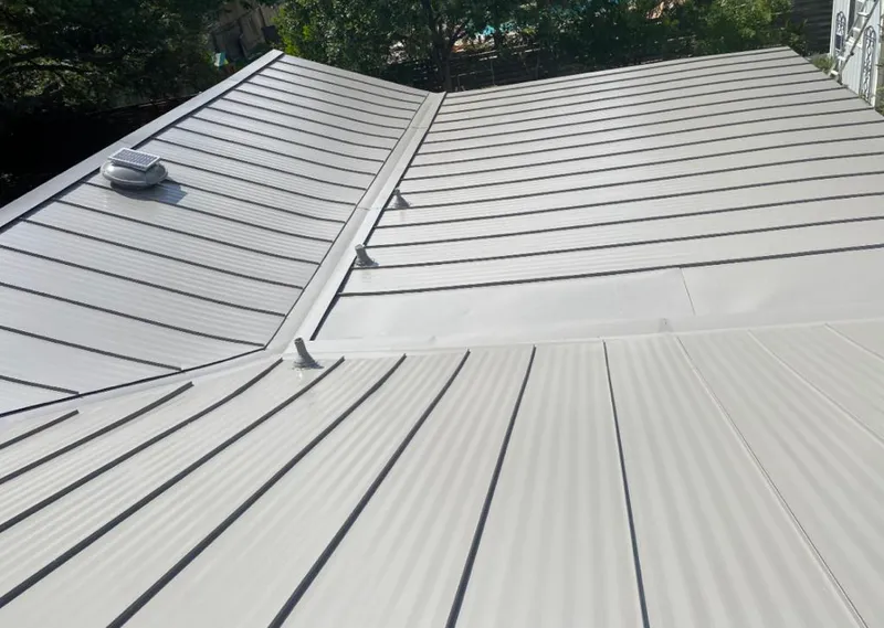 Solar attic fan installed on a metal roof for Roof Ventilation in Bright